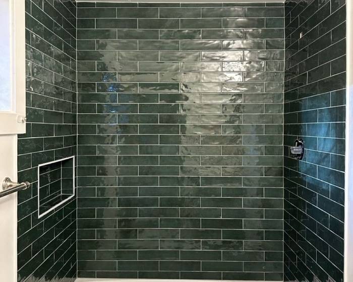 Remodeled bathroom with green subway tile, a niche and a new soaking tub