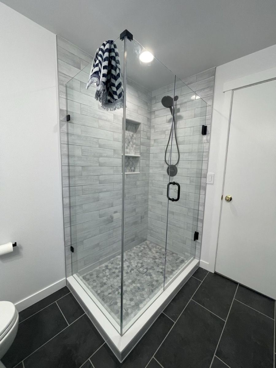 Corner glass shower with a pebble floor