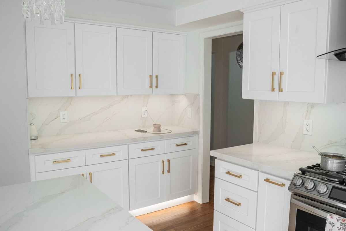 White kitchen with quartz counters and a marble-look backsplash